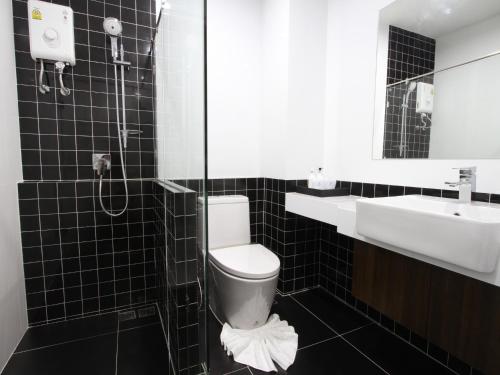 a bathroom with a toilet and a sink and a shower at Anna-Nava Pakkret Hotel in Nonthaburi