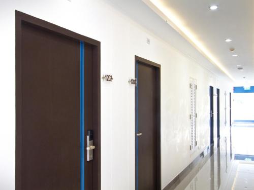 a corridor with two doors in a building at Anna-Nava Pakkret Hotel in Nonthaburi