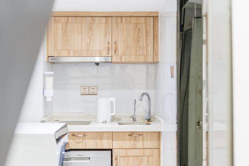 a kitchen with wooden cabinets and a sink at SEEU Designer Apartment in Shenzhen