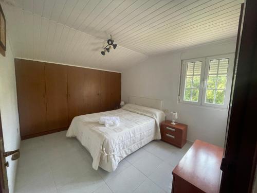 a bedroom with a bed and a window at Lar Etxea O Barqueiro in O Barqueiro