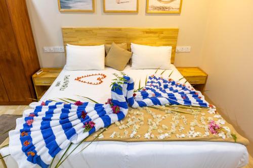 a bedroom with a bed with white sheets and pillows at Thilavaru Inn in Dhangethi