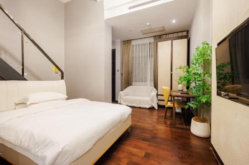 a bedroom with a bed and a desk and a table at SEEU Designer Apartment in Shenzhen