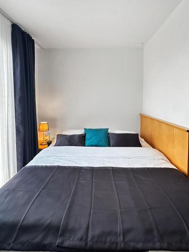 a bedroom with a large bed with a wooden headboard at Centra Hotel Zurich in Bassersdorf