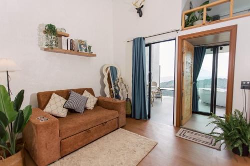 a living room with a couch and a sliding glass door at Sinsup villa Doichang 2 in Ban Huai Khai