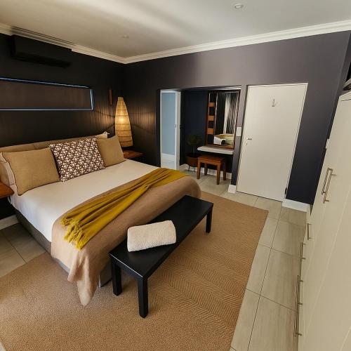 a bedroom with a large bed and a table at 1442 Marina by Double Portion in Jeffreys Bay