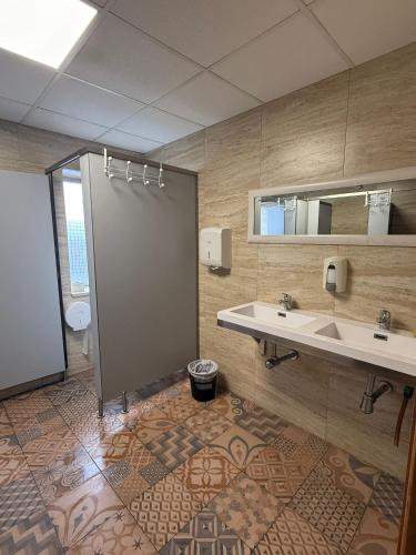 a bathroom with a shower and a sink and a mirror at ALBERGUE Pasiño A Pasiño in Portomarin