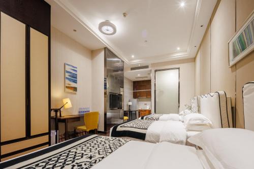a hotel room with two beds and a desk at SEEU Designer Apartment in Shenzhen