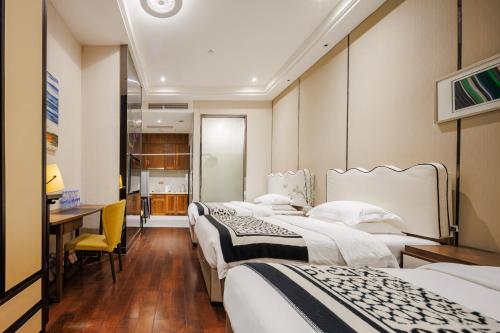 a hotel room with three beds and a desk at SEEU Designer Apartment in Shenzhen