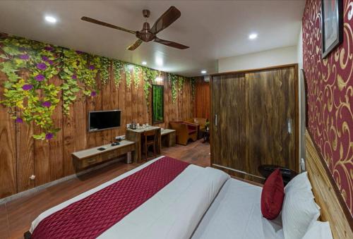 a bedroom with a bed and a wall with flowers at Hotel Blooming Soul in Kolhapur