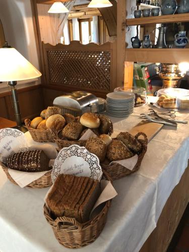 a table topped with baskets of bread and pastries at Hotel St. Ulrich Garni in Ottobeuren
