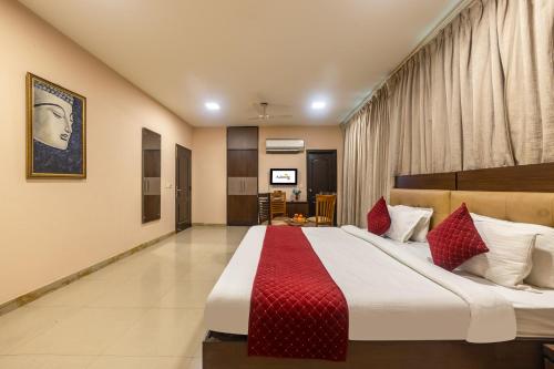 a bedroom with a large bed with red pillows at Hotel Admire Inn Sector-50 by ASPL in Noida