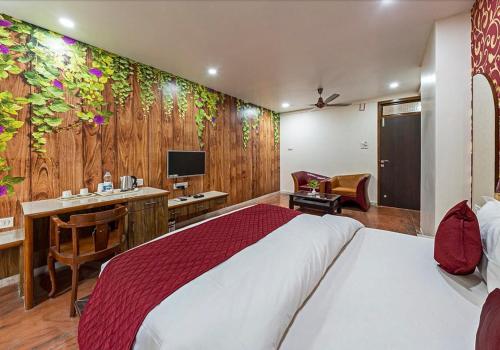 a bedroom with a bed and a desk with a computer at Hotel Blooming Soul in Kolhapur