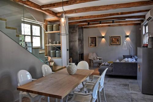 a dining room with a wooden table and white chairs at Villa Zita with private pool and sauna in Potpićan