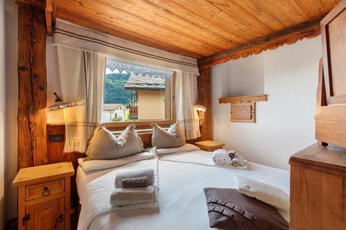 a bedroom with a large white bed with a window at Affittacamere Jour Et Nuit in Torgnon