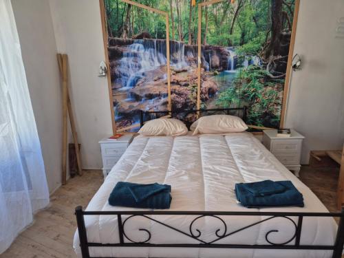 a bedroom with a bed with a painting on the wall at La Dorette - Dans le parc naturel LIvradois-Forez in Arlanc