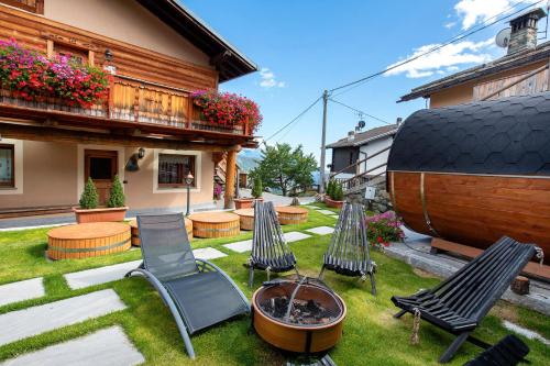 a yard with chairs and a fire pit and a house at Affittacamere Jour Et Nuit in Torgnon