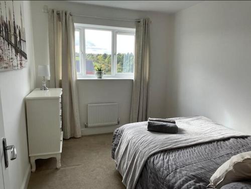 a white bedroom with a bed and a window at Four Bedroom House By Brookland Stays Serviced Accommodation Short Lets Leeds With Free WiFi in Morley