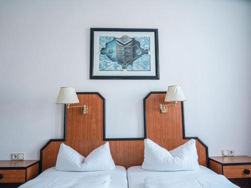 a hotel room with two beds and a picture on the wall at Apart-Hotel-Pension in Taucha