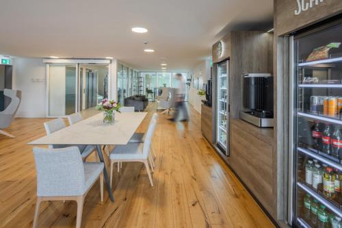 a dining room with a table and chairs and a refrigerator at LMS - La Maison Suisse - Döttingen in Döttingen