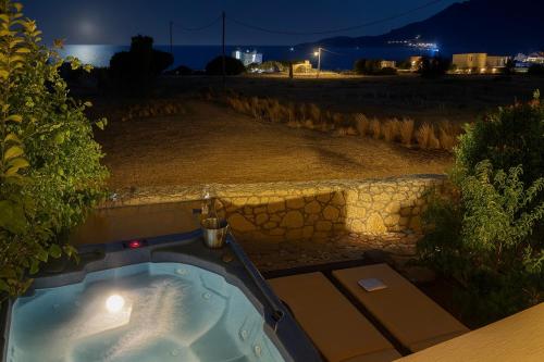 a jacuzzi tub in a yard at night at Orionas in Tsoútsouros