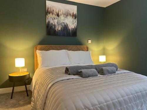 a bedroom with a large bed with two lamps at Kingsley Gardens Luxury Apartments in Northampton
