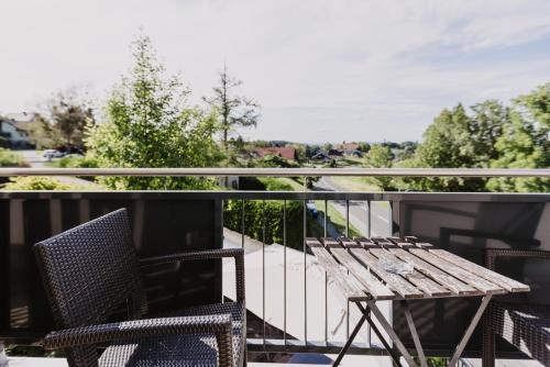 a balcony with a wooden table and two chairs at Ewitsch 13 - Hotel Garni in Berghausen