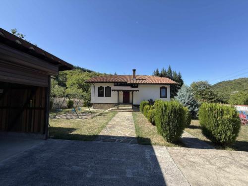 una casa con vialetto che porta a un garage di Къща за гости Сияйна Зора a Plachkovtsi
