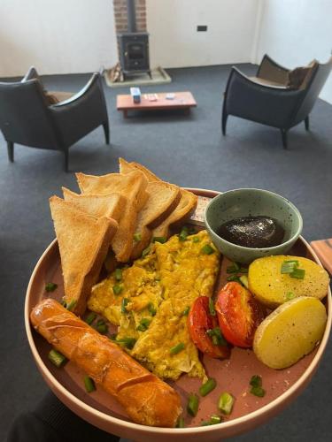a plate of eggs and chips and a bowl of dips at Journey Junction Hostel in Nuwara Eliya
