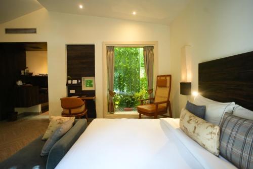 a bedroom with a bed and a chair and a window at The Solluna Resort in Marchula