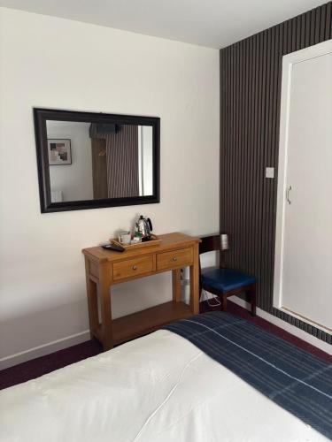 a bedroom with a desk and a mirror and a bed at Draper Rooms Galway in Galway