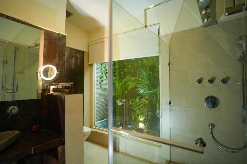 a bathroom with a shower with a glass door at The Solluna Resort in Marchula
