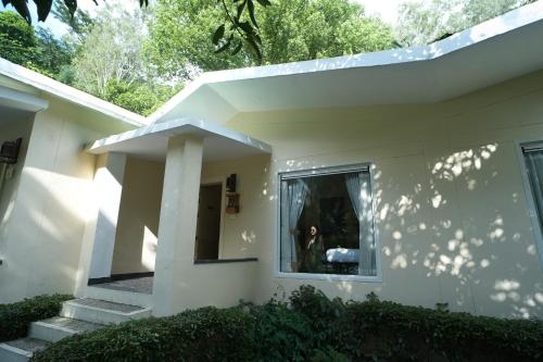 a woman is looking out the window of a house at The Solluna Resort in Marchula