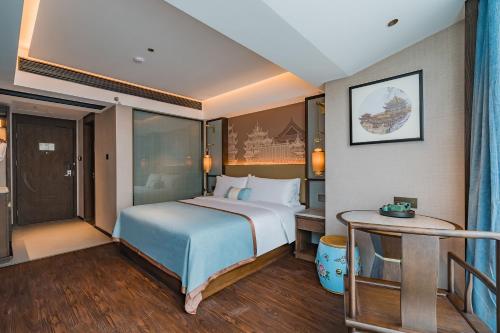 a hotel room with a bed and a table at Till Bright Hotel, Foshan Shunde Ronggui Station Branch in Shunde