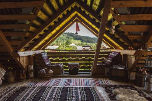 a attic room with two chairs and a window at Aura's Guest House in Sadova