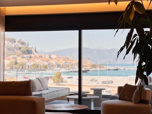 a living room with couches and a large glass window at FOS Luxury Apartment with View of Nafplio in Nafplio
