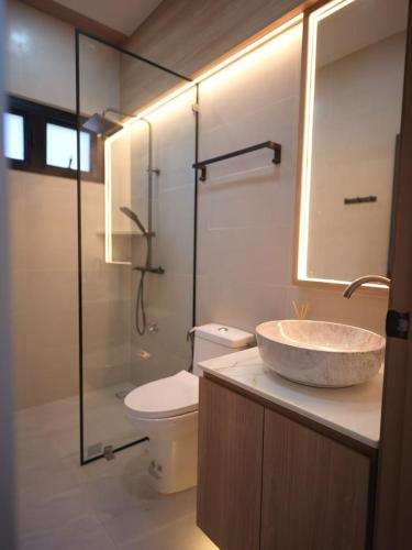 a bathroom with a sink and a toilet and a shower at Private three-bedroom home in Chiang Mai