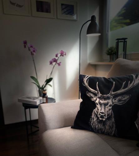 a cushion with a picture of a deer on a couch at Ferienwohnung Paradies Hella in Kippenheim