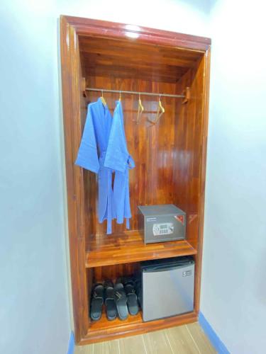 a room with a shelf with clothes and a box at Sadakham Legend Hotel in Luang Prabang
