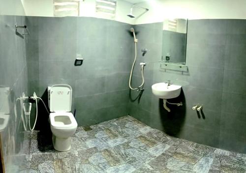 a bathroom with a toilet and a sink at Wooden Eco Cottage in Katiyawa