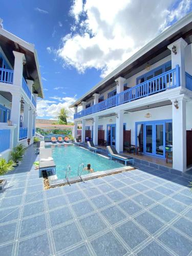 a house with a swimming pool in front of it at Sadakham Legend Hotel in Luang Prabang