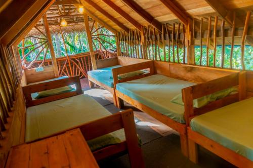 a room with three beds and a table and chairs at Wooden Eco Cottage in Katiyawa