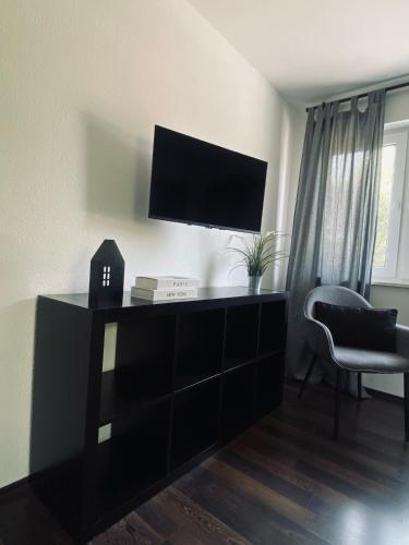 a living room with a flat screen tv on a wall at Ferienwohnung Paradies Hella in Kippenheim