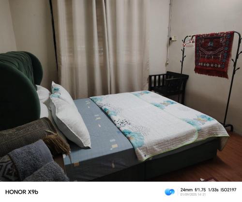 a bed with a quilt on it in a room at Ed 02 manjung in Seri Manjung