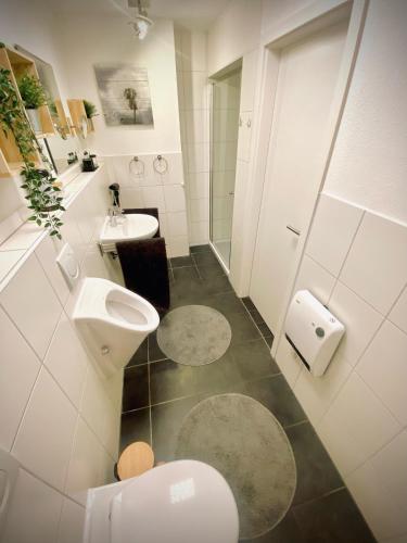 a white bathroom with a toilet and a sink at Ferienwohnung Paradies Hella in Kippenheim
