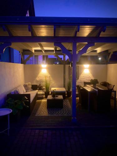 a patio with couches and tables at night at Ferienwohnung Paradies Hella in Kippenheim