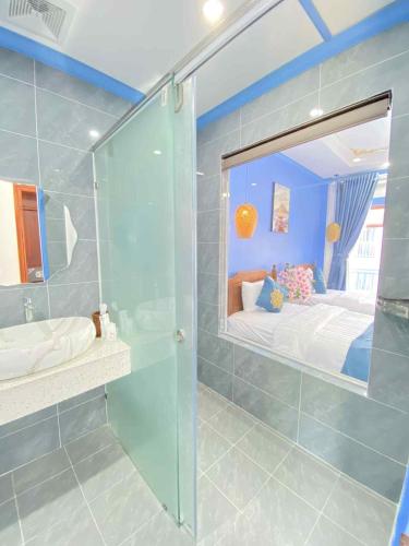 a bathroom with a glass shower and a bed at Sadakham Legend Hotel in Luang Prabang