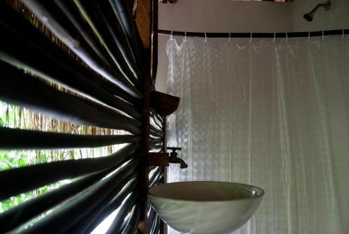 La salle de bains est pourvue d'un lavabo et d'une fenêtre. dans l'établissement Playa Pikua Ecolodge, à Guachaca