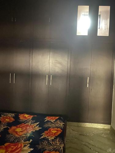 a bedroom with gray cabinets and a bed with a blanket at Swamiji niwas in Morādābād
