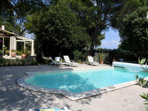 une piscine avec deux chaises et une maison dans l'établissement Les chambres d'Adeline - B&B, à Murs