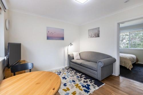a living room with a couch and a table at Yarralumla Apartment Stay Queen Bed and Sofa Bed Free Parking in Yarralumla